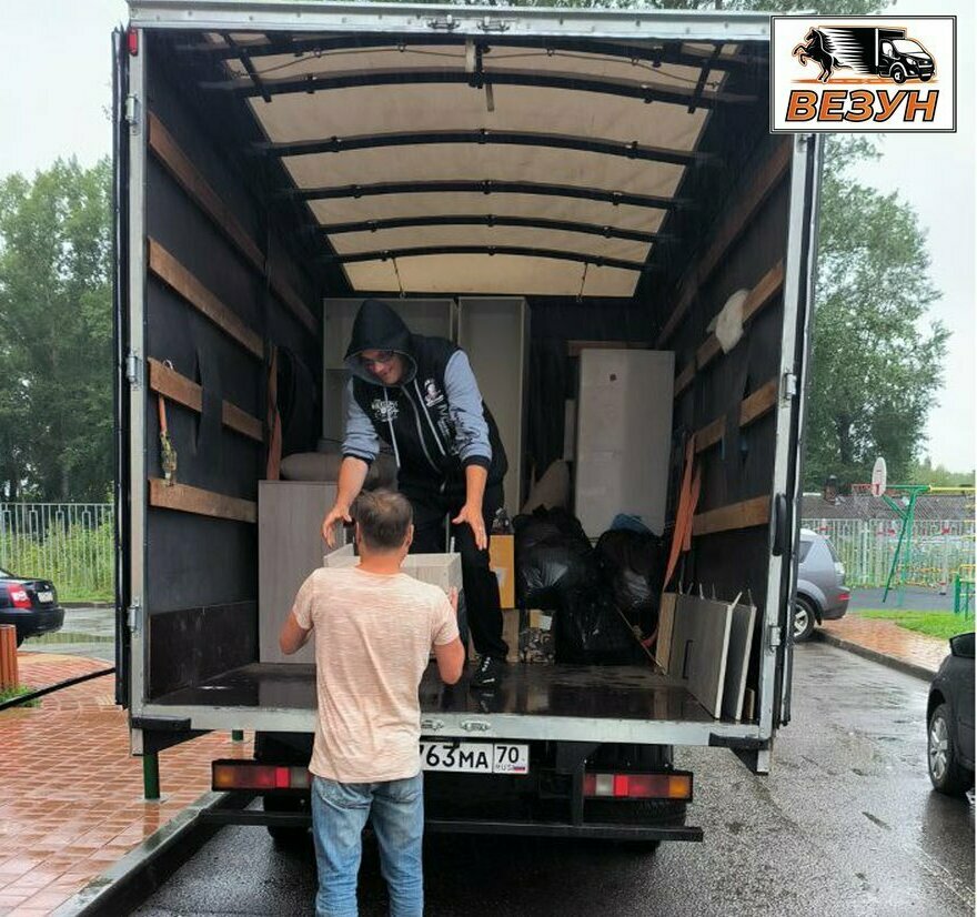 Грузчики выносят мебель из подъезда — Газель у дома в Томске