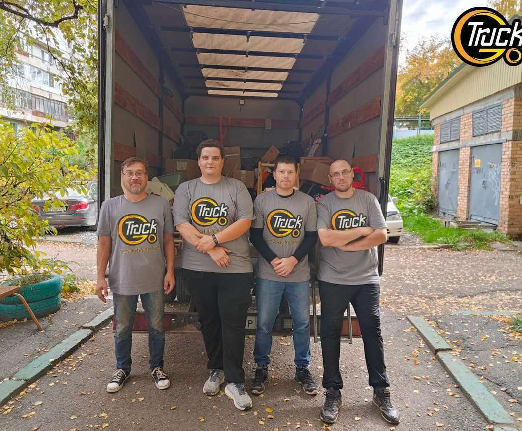 Грузчики с тележками и ремнями работают с Газелью в Томске